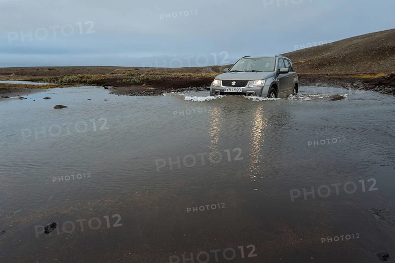 Off road vehicle drives through waterfurt