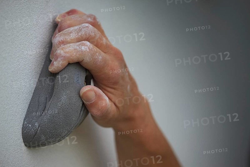 A hand holding on to an artificial climbing grip