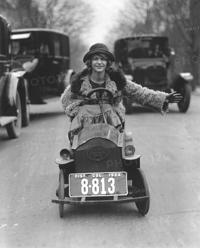 Woman driving in a soapbox on a busy street