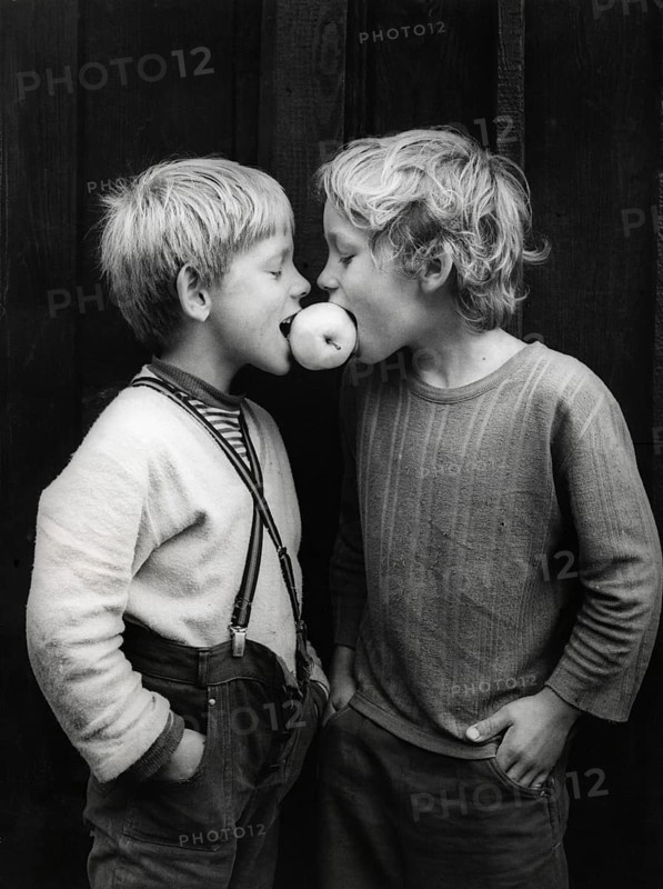 Two boys share an apple about 1970s