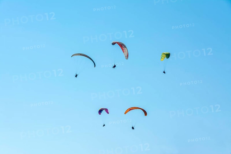 Paragliders in a blue sky