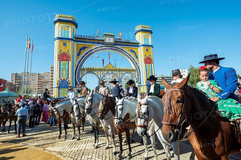 Rider on decorated horses with traditional clothes in front of lighted entrance gate