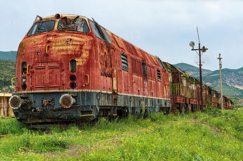 Decayed locomotive and train at former railway station