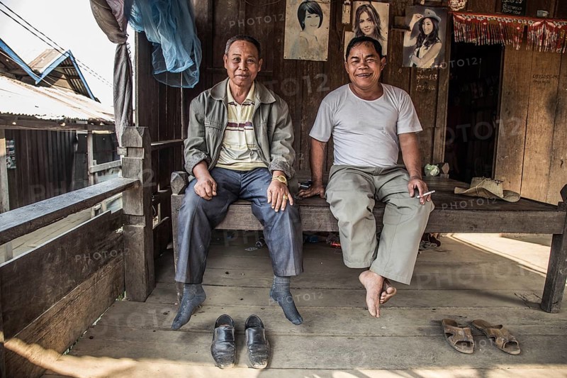 Two locals are sitting in their hut