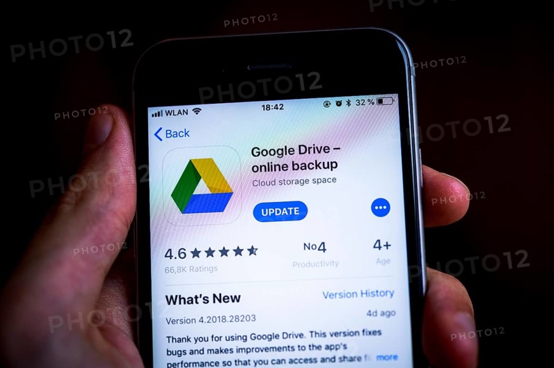 Hand holding an iPhone displaying Google Drive app
