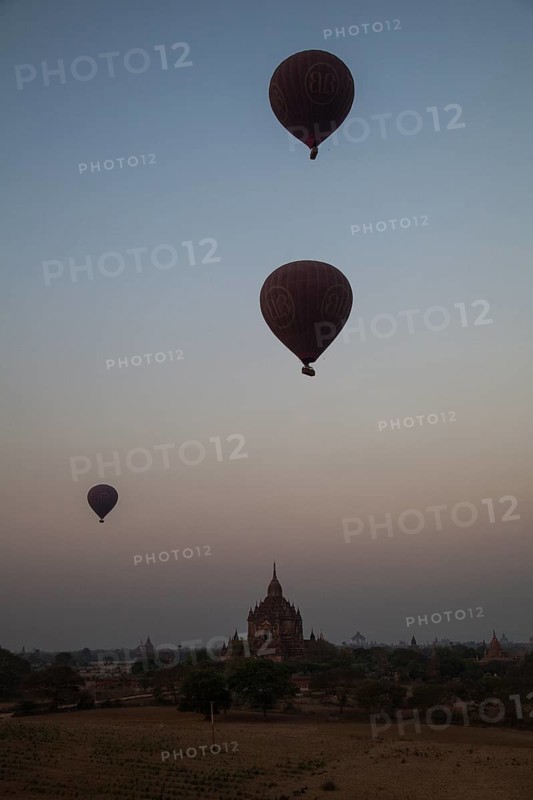 Hot air balloons at sunrise over temples and pagodas