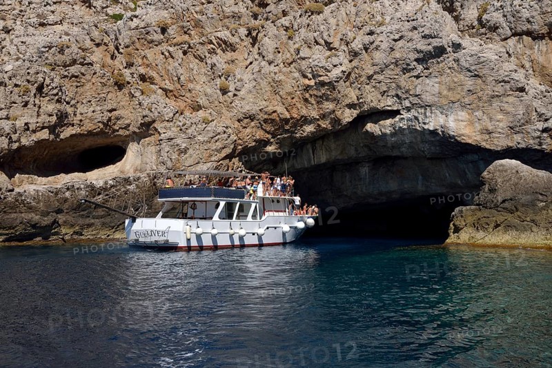 Tourist boat entering the sea cave Grotta Perciata
