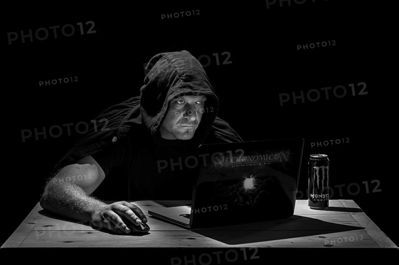 Man is sitting at the table in a dark room