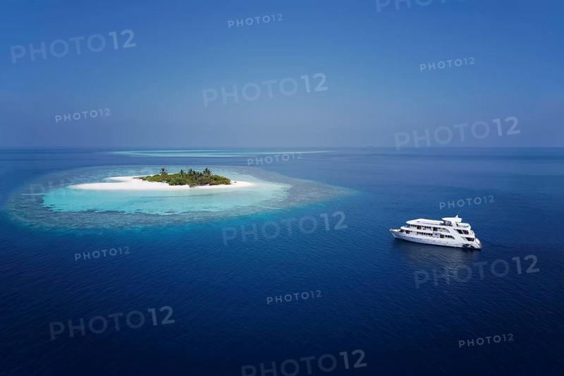 Diving safari ship MS Keana anchors off uninhabited palm island