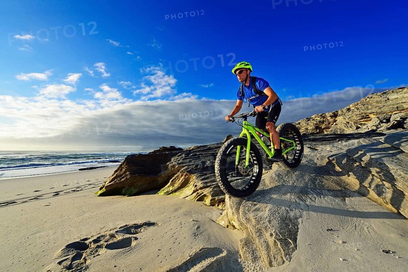 Mountain biker with fat bike on the beach