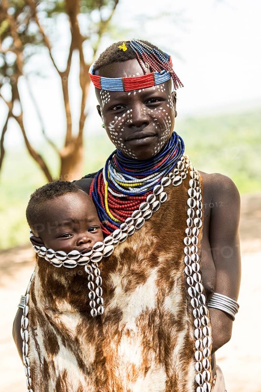 Young woman with toddler in traditional clothes made of goatskin