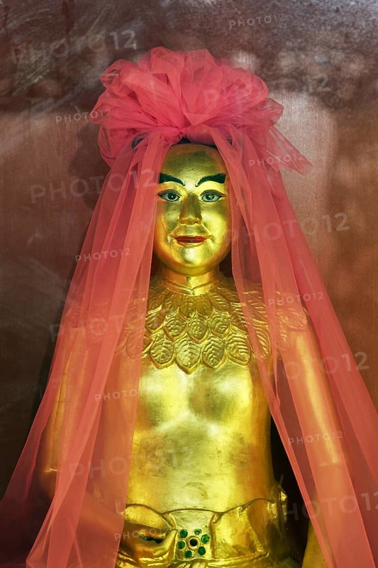 Golden god figure with pink veil