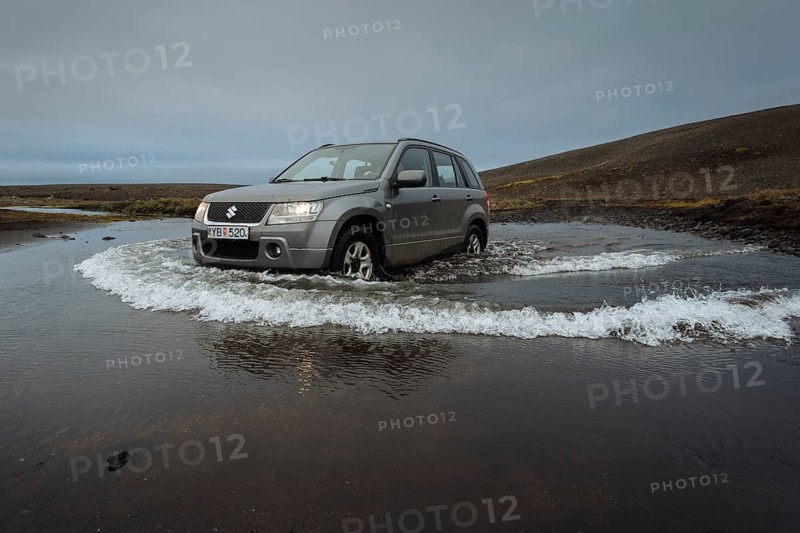 Off road vehicle drives through waterfurt