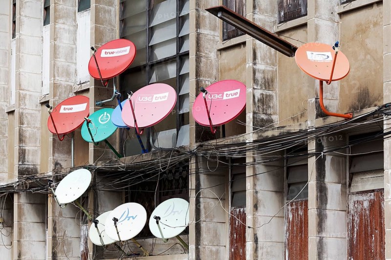 Colourful satellite dishes on a building