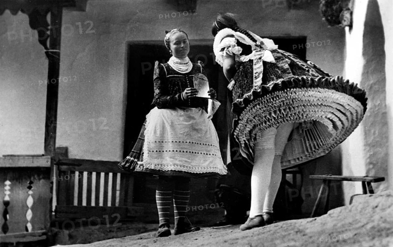 Two women in traditional costumes with many petticoats