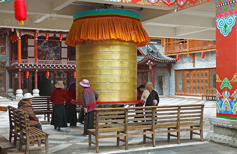 Women turn a prayer wheel