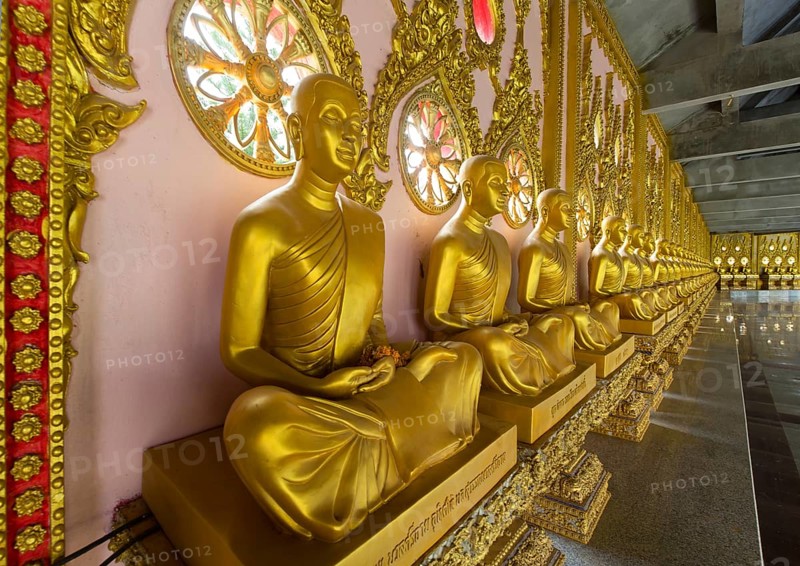 Row of golden Buddha statues in the corridor of the Phra Maha Chedi Chai Mongkhon Pagoda