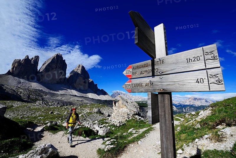Hiker below the Drei Zinnen-Hutte in front of the northern walls of the Three Peaks of Lavaredo