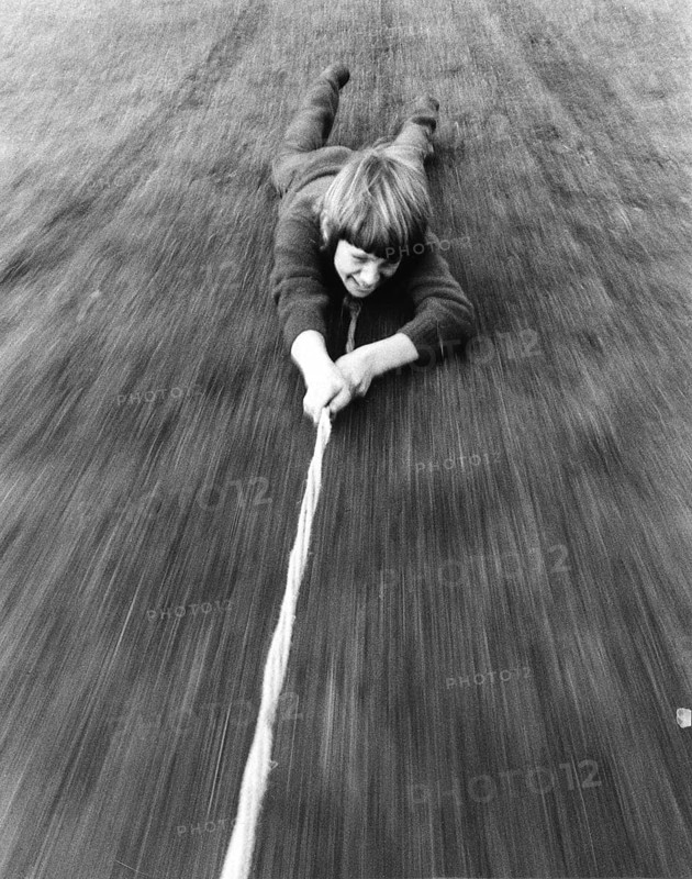 Boy is pulled over the ground on a rope