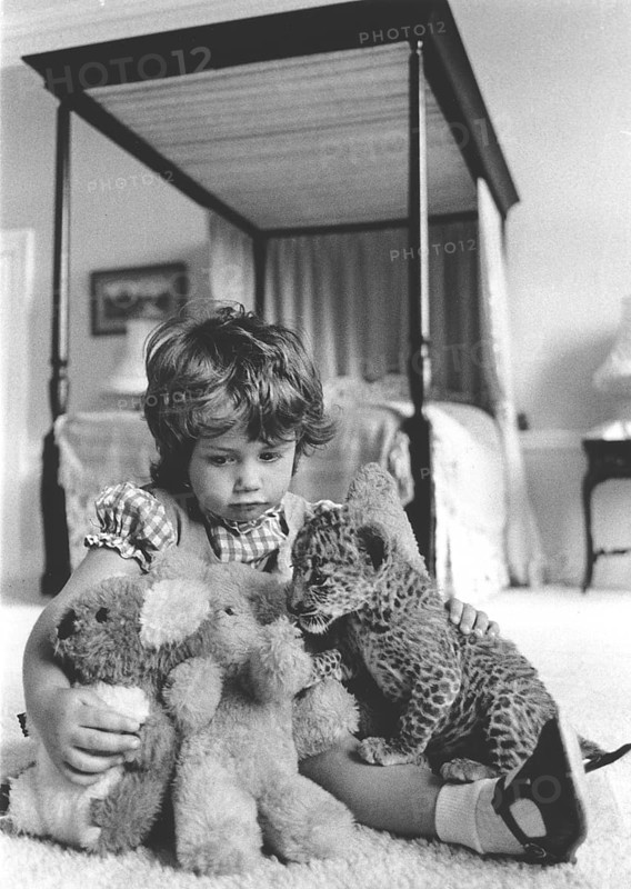 Girl plays with a baby predator and stuffed animals