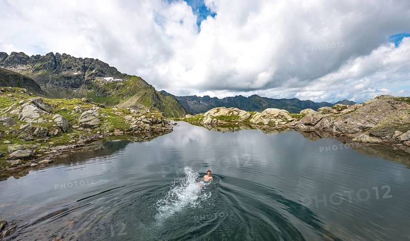 Young man swimming in a small lake