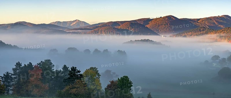 Autumn foggy atmosphere with Schneeberg and pilgrimage church Hafnerberg