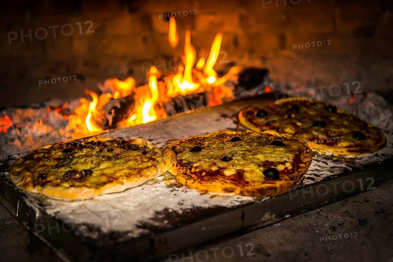 Pizza is baked in a pizza oven