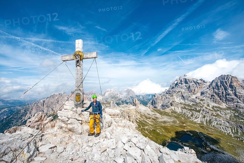 Hiker at the peak cross of the Paternkofel