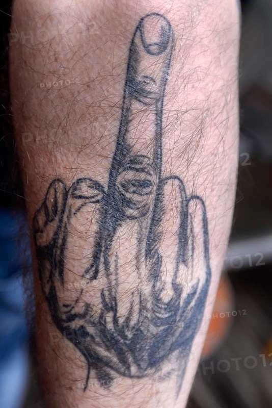 Tattoo with middle finger on arm