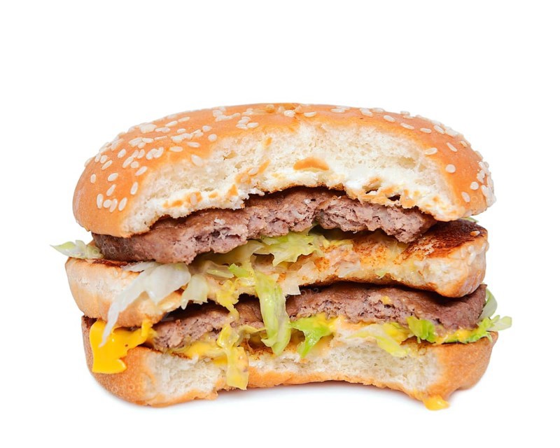 Half eaten burger against a white background