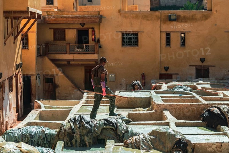 Worker dyeing leather