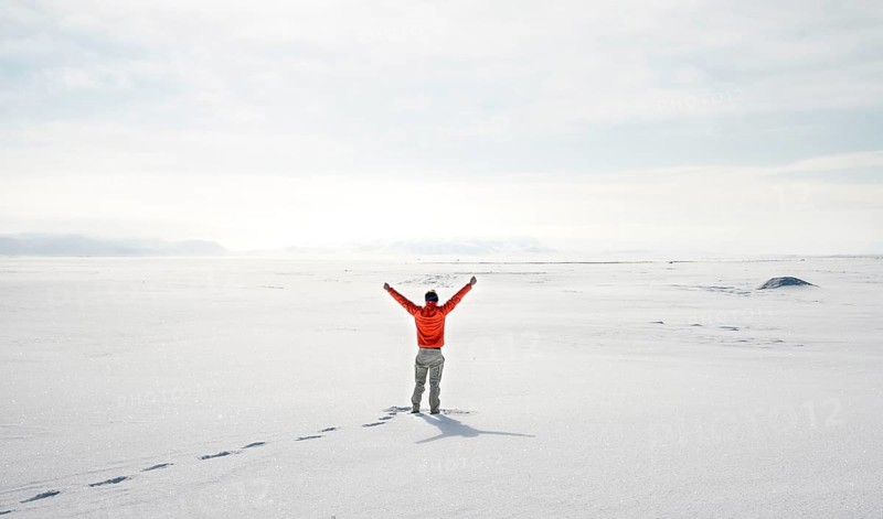 Young man stands alone in snowy landscape