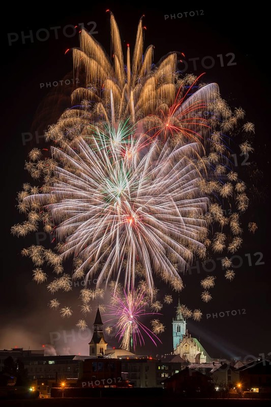 Fireworks over Schwaz on New Year's Eve with hospital church and parish church