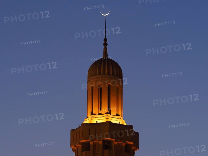 Crescent Moon over Illuminated Minaret