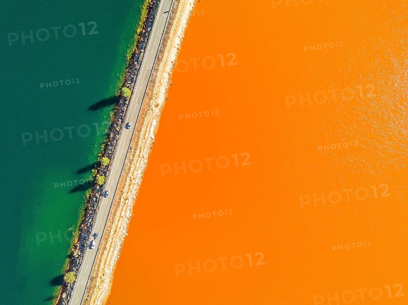 Street trough orange and blue lakes in mining region