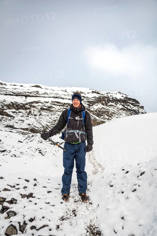 Hiker with ice pick during hike on the glacier