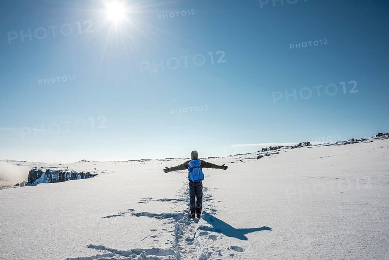 Young man walks through snowy countryside