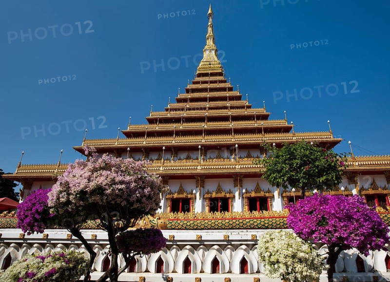 Flowering bushes in front of nine-story stupa Phra Mahathat Kaen Kakhon