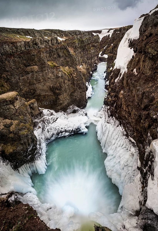 Partially icy waterfall in a canyon