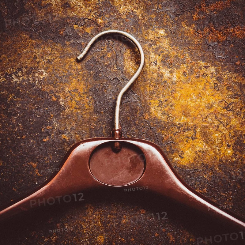 Wooden clothes hanger on rusty ground