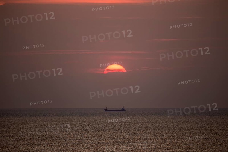 Mediterranean sea with cargo ship in the sunset at Tarragona