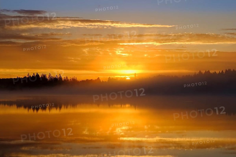 Sunrise with early morning mist over Kirchsee with Reutberg Monastery
