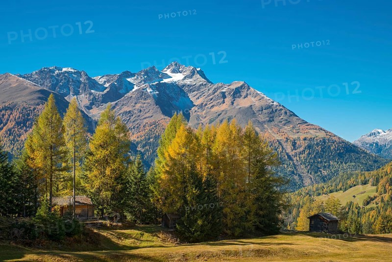 Autumnal mountain landscape with alpine huts