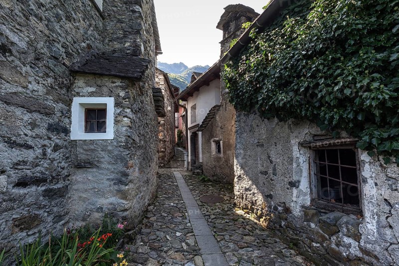 Typical Ticino stone houses in a narrow alleyway in the mountain village of Bordei