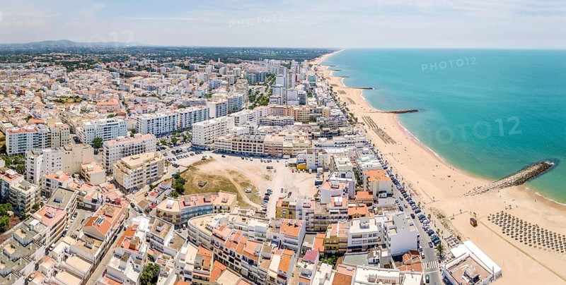 White architecture and blue Atlantic ocean in Quarteira resort during sunny day