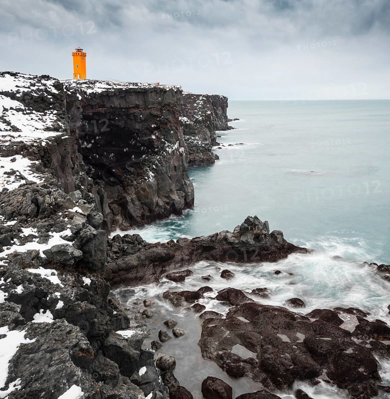 Orange lighthouse Ondverdarnes stands on a dark cliff