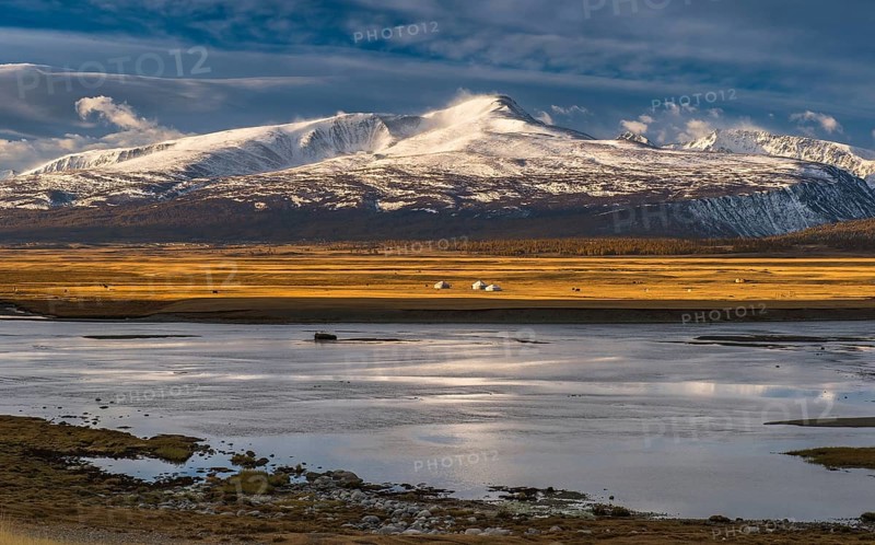 Khurgan Lake with snow-covered mountains in the back