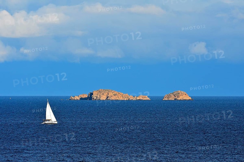 Sailboat in front of rocky islands