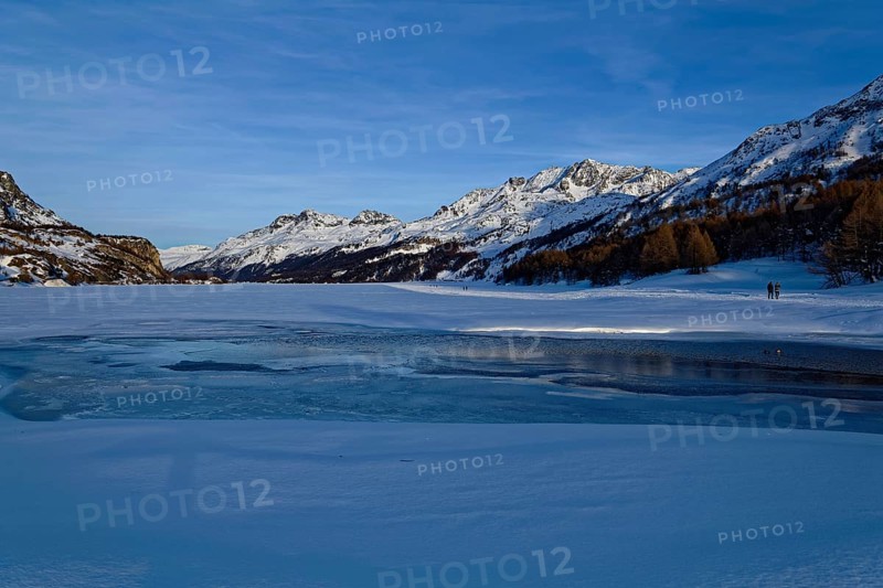 View over frozen Lake Silsersee to the Bernina Group with peaks Piz Rosatsch