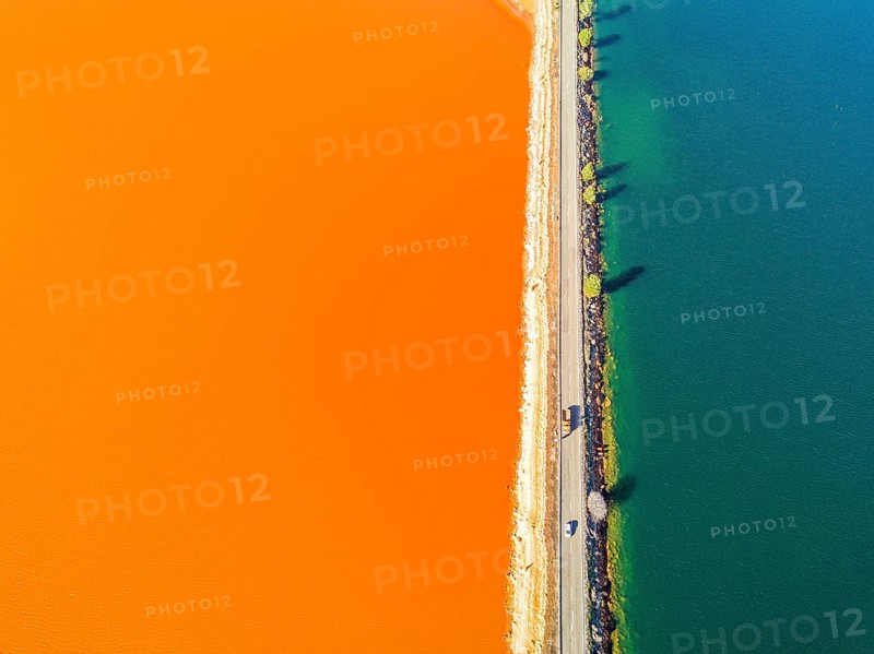 Street trough orange and blue lakes in mining region